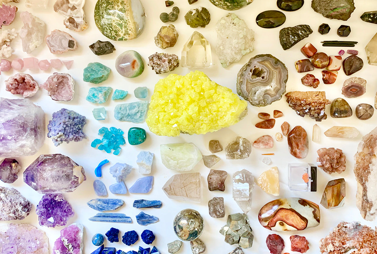 Collection of various colorful crystals and minerals on a white background